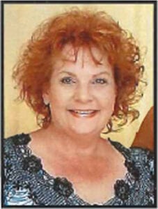 A woman with red hair, smiling (Claudia Elston)