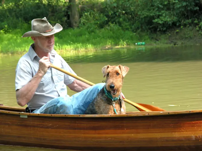 A dog and a man on a canoe