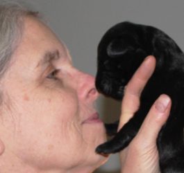 A woman holding a pup to her nose (different angle)