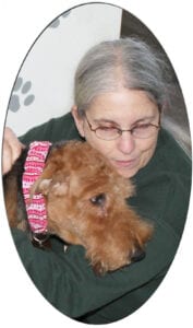 Woman embracing tearful Airedale in patterned collar
