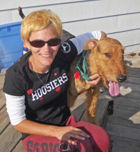 Smiling person with dog on wooden deck SOAR